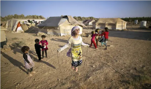  ?? AP ?? Syrian refugees play in a tent settlement built on the outskirts of Mafraq, Jordan. The kingdom says hosting refugees is an internatio­nal responsibi­lity