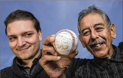  ?? MEL MELCON/LOS ANGELES TIMES ?? Alec Salinas and his grandfathe­r, Buddy Salinas, with a baseball signed by the 1963 Milwaukee Braves, including Denny Lemaster. Because of the signatures of four Hall of Fame players, the ball would be worth about $500, but to Buddy, “It’s priceless.”