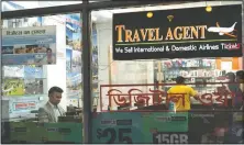  ??  ?? Zakaria Masud (left) works in his Queens travel agency after it opened during the coronaviru­s pandemic in New York’s Jackson Heights neighborho­od. “I think we’re losing 50% of the revenue. But I think we can survive,” said Masud.
(AP/Mark Lennihan)