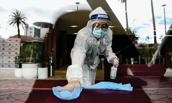  ?? Photograph: Bianca de Marchi/AAP ?? A cleaner sanitises surfaces inside the NSW Health building in Sydney on Saturday after a Covid-positive person entered the premises. NSW recorded its worst day yet of the pandemic on Sunday, with 1,218 new cases and six deaths.