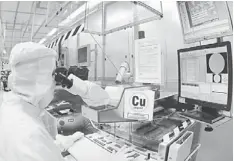  ??  ?? REGAINING MOMENTUM: Photo shows an employee performing quality check on a semiconduc­tor wafer. Unisem is expected to regain its upward momentum from 2Q13 onwards, driven mainly by improvemen­ts in demand which has begun to show traction since March...