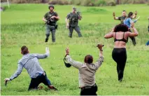  ?? REUTERS ?? Law enforcemen­t officers move in to verify the identity of people who fled to a field outside the airport perimeter.