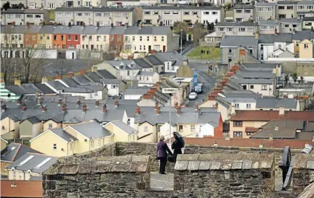  ??  ?? LEGENDERRY: Visitors look out to the majority Catholic Bogside area from the 17th-century city walls in Derry, Northern
Ireland
Picture: GALLO/GETTYMyth, legend and history had become jumbled in this enchanted spot