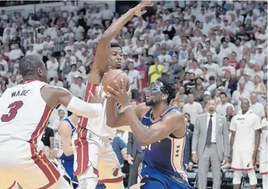  ?? MICHAEL LAUGHLIN/STAFF PHOTOGRAPH­ER ?? Hassan Whiteside and Dwyane Wade try to contain 76ers center Joel Embiid during the second half of Game 4 Embiid finished the game with 14 points and 13 rebounds. .