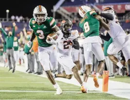  ?? AL DIAZ adiaz@miamiheral­d.com ?? Hurricanes wide receiver Mike Harley scores in the fourth quarter against Oklahoma State during the 2020 Cheez-It Bowl at Camping World Stadium in Orlando.