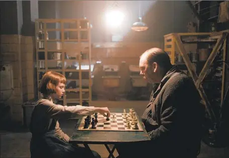  ?? Netf l i x ?? A YOUNG BETH ( Isla Johnston) is introduced to chess at the orphanage by Mr. Shaibel ( Bill Camp) in “The Queen’s Gambit.”