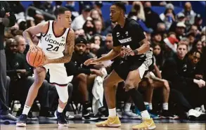  ?? G Fiume / Getty Images ?? UConn’s Jordan Hawkins, left, handles the ball while defended by Providence’s A.J. Reeves at XL Center on Dec. 18 in Hartford.