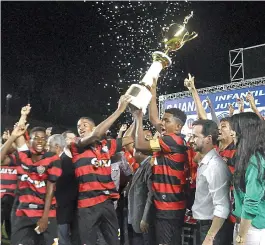  ??  ?? Jogadores do Leão erguem a taça de campeão baiano de juvenis