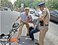  ?? — DC ?? Policemen help a biker who fell down from his bike after hitting a barricade near the Osmania University police station on Wednesday.