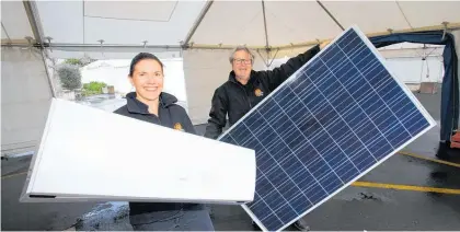 ?? Photo / John Stone ?? Sarah Blithe and Murray Batger set up the Huband’s Energy solar panel display in readiness for the Northland Home &amp; Lifestyle Show.