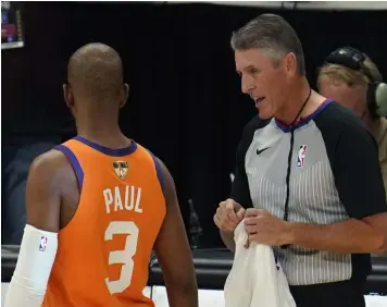  ??  ?? Referee Scott Foster talks with Phoenix Suns guard Chris Paul (3) before the start of Game 6 of basketball's NBA Finals against the Milwaukee Bucks in Milwaukee. The NBA said Saturday, Aug. 28, 2021, that its referees have all agreed to be vaccinated as a condition for working games this season. (AP Photo/Paul Sancya, File)