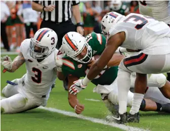  ?? AP PHOTO ?? PAYDIRT: Miami quarterbac­k Malik Rosier dives in for a touchdown as Virginia’s Quin Blanding, left, and Bryce Hall defend in the second half yesterday.