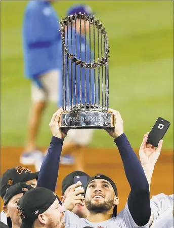  ?? Brett Coomer / Houston Chronicle ?? Astros center fielder George Springer hoists the World Series trophy as the Astros celebrate beating the Los Angeles Dodgers in Game 7 of the World Series on Nov. 1.