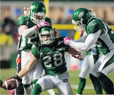  ?? LIAM RICHARDS/The Canadian Press file photo ?? Saskatchew­an Roughrider­s linebacker Diamond Ferri, left, and defensive end Ricky Foley, right, congratula­te linebacker Craig Butler on an intercepti­on against the B.C. Lions during the second quarter of CFL football action in Regina Saturday.