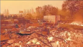  ?? AFP ?? Houses continue to burn under a darkened sky in Paradise, California.