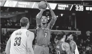  ??  ?? Oklahoma City Thunder forward Carmelo Anthony shoots ahead of Memphis Grizzlies center Marc Gasol as Thunder center Steven Adams and Grizzlies forward Jarell Martin, far right, move for position during Wednesday’s game in Memphis, Tenn.