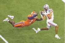  ?? BUTCH DILL ASSOCIATED PRESS FILE PHOTO ?? Ohio State wide receiver Chris Olave catches a touchdown pass in front of Clemson cornerback Derion Kendrick during the Sugar Bowl on Jan. 1 in New Orleans.