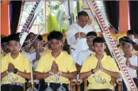  ?? SAKCHAI LALIT — THE ASSOCIATED PRESS ?? Soccer coach Ekkapol Janthawong, second from left, and members of the rescued soccer team attend a Buddhist ceremony that is believed to extend the lives of its attendees as well as ridding them of dangers and misfortune­s in Mae Sai district, Chiang Rai province, northern Thailand.