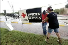  ??  ?? In this Aug. 25 file photo, volunteers set up signage outside the Civic Center, where the Red Cross has set up a shelter for those who evacuated their homes due to storm damage in Beaumont, Texas. KIM BRENT/THE BEAUMONT ENTERPRISE VIA AP