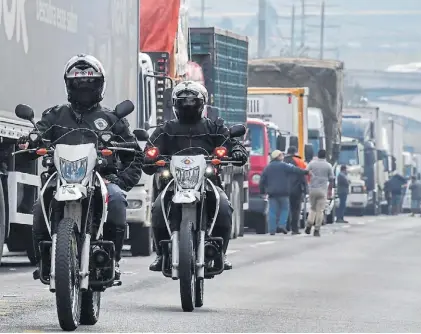  ?? AFP ?? Situación. Dos patrullero­s pasan junto a una de los piquetes de los camioneros en una ruta de San Pablo.