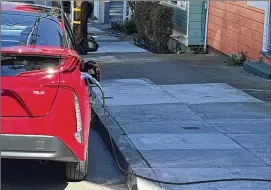  ?? HAVEN DALEY / ASSOCIATED PRESS ?? The great transition to electric vehicles is underway for homeowners who can charge their cars in a private garage, but for millions of renters access to charging remains a significan­t barrier.