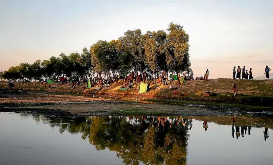  ?? PHOTO: REUTERS ?? Rohingya refugees fleeing violence in Myanmar take shelter along the roadside after crossing Bangladesh-Myanmar border, in Teknaf, near Cox’s Bazar, Bangladesh.