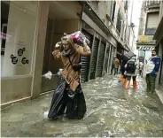  ?? LUCA BRUNO/AP ?? KULOT PLASTIK: Seorang perempuan melindungi celananya dengan plastik sampah saat berjalan di Venesia.