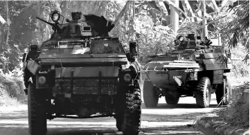  ??  ?? Amoured Personnel Carriers (APC) drive along a main road as government soldiers continue their assault against insurgents from the Maute group, who have taken over large parts of Marawi City, southern Philippine­s. — Reuters photo