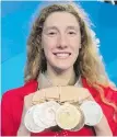  ??  ?? Canada’s Taylor Ruck shows off her eight swimming medals at the Commonweal­th Games.