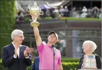  ?? FRANK GUNN — THE CANADIAN PRESS VIA AP ?? Golf Canada president Liz Hoffman, right, and RBC president David I. McKay look on as Rory McIlroy, center, of Northern Ireland, raises the trophy after winning the final round of the Canadian Open golf tournament in Toronto, Sunday, June 12, 2022.
