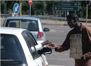  ??  ?? William Ncithi, a beggar at the conner of George Storrar and Van Wouw streets in Pretoria, receives some assistance from a sympatheti­c motorist.