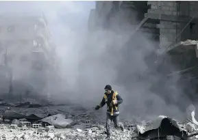  ?? ABDULMONAM EASSA / AFP / GETTY IMAGES ?? A civil defence volunteer checks the site of an airstrike in the rebel-held town of Saqba, in the Eastern Ghouta region outside of Damascus, on Friday. Another 32 civilians were killed in the sixth straight day of Syrian regime airstrikes.