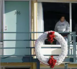  ?? MARK HUMPHREY — THE ASSOCIATED PRESS FILE ?? A woman looks out of a window while visiting the National Civil Rights Museum located at the Lorraine Motel in Memphis, Tenn., on the nationwide holiday honoring Martin Luther King Jr. The wreath marks the location where King was killed while standing...