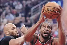  ?? FRANK GUNN THE CANADIAN PRESS ?? Raptors forward Kawhi Leonard (2) drives to the basket as Minnesota Timberwolv­es forward Taj Gibson (67) defends during first half action in Toronto on Wednesday. For game results, go to therecord.com.