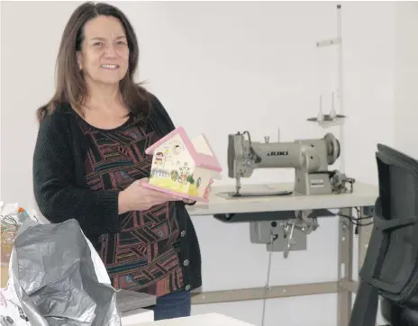  ??  ?? The Bridge director Linda Walker holds sample of items to be produced in skills training classes and sold to support programs. DARLENE POLACHIC