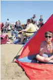  ?? Left and above, crowds witness an explosion on the beach during a Spitfire dogfight ??