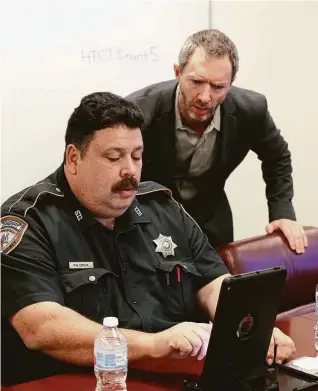  ?? Steve Gonzales / Houston Chronicle ?? Cloud 9 CEO J.C. Adams aids Harris County Sheriff ’s Deputy Fred Lerma during a training session of a telepsychi­atry program last week. Cloud 9 helped make the app a reality.