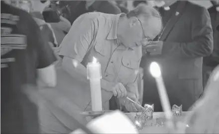  ?? STU NEATBY/THE GUARDIAN ?? Residents light candles at a vigil on Friday night at St. John the Evangelist Church on Friday night in Fredericto­n. A shooting on Friday morning claimed the lives of four individual­s, including two police officers.