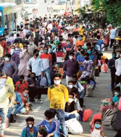  ??  ?? MIGRANTS in Surat waiting for buses to reach the railway station, on May 29.