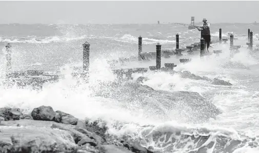  ?? MIKE STOCKER/SOUTH FLORIDA SUN SENTINEL ?? George Emmert casts his line into the surf at the jetty along the beach in Fort Pierce as Hurricane Dorian continues to churn offshore.