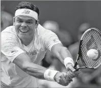  ?? AP PHOTO ?? Milos Raonic of Canada returns the ball to John Millman of Australia during their men’s singles match Wednesday at the Wimbledon tennis championsh­ips in London.