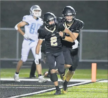  ?? BEN HASTYY — READING EAGLE ?? Berks Catholic’s Connor Gundersen (2) is congratula­ted by his teammate Bradley Hoffman after scoring in the first quarter of the Saints’ 49-7 victory over Daniel Boone.