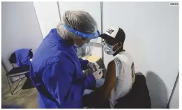  ?? XINHUA ?? BOGOTÁ.UNA trabajador­a de la salud aplica a un hombre una dosis de una vacuna contra el COVID-19.