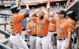  ?? Leon Halip / Getty Images ?? Jason Castro, left, celebrates his seventh-inning, bases-loaded single that drove in two runs and gave the Astros the lead for good in a 10-8 win over Detroit.