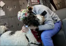  ?? ?? Patient technician Holly Riegel hugs Gracie in a break room after tending to COVID-19 patients.