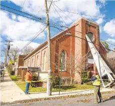  ?? APRILGAMIZ/THE MORNING CALL ?? Work crews examine Trinity Baptist Church in South Side Easton, where strong wind ripped the steeple off the building, taking down power lines and damaging a nearby car.