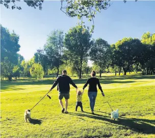  ??  ?? ●●A family make the most of the weather by enjoying a stroll on the course