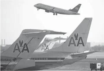  ??  ?? LATEST COMMERCIAL MAMMOTH: Above, US Airways Group Inc. airplane taxis behind a AMR Corp.’s American Airlines airplane at Reagan National Airport in Washington, D.C., on Feb 14. Above right, a US Airways Group Inc. airplane takes off behind AMR Corp.’s...