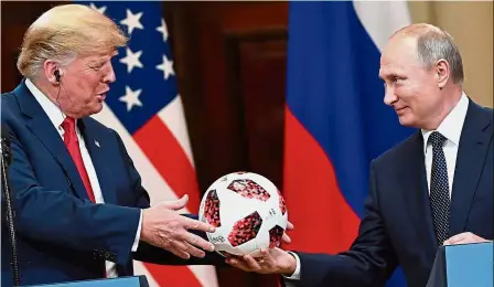  ??  ?? World Cup gift: Putin presenting a 2018 Russia World Cup official ball to Trump during a joint press conference at the Presidenti­al Palace in Helsinki. — AFP