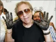  ?? KEVORK DJANSEZIAN — THE ASSOCIATED PRESS FILE ?? Hal Blaine holds up his hands covered in cement after placing them in wet cement with Don Randi and Glen Campbell, representi­ng The Wrecking Crew following an induction ceremony for Hollywood’s RockWalk in Los Angeles.